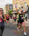 Runner with hands up running in the Hackney Half Marathon