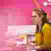 Someone working at their desk against a pink background