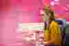 Someone working at their desk against a pink background